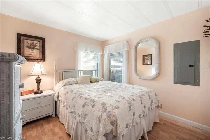 Bedroom with electric panel and light wood-style floors