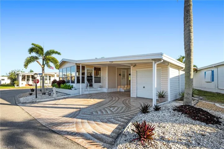 View of front of home with driveway, an attached garage, and an attached carport