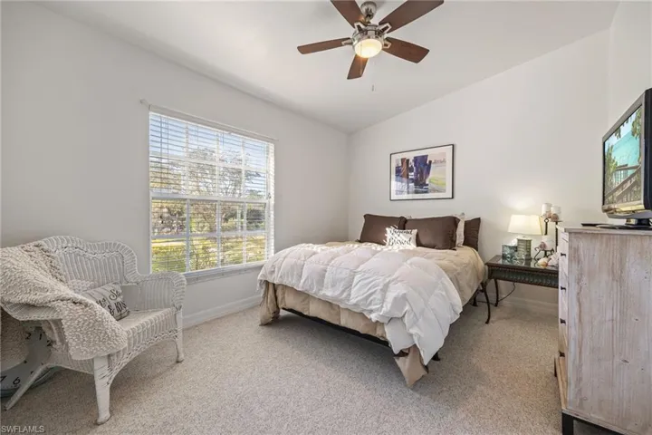 Bedroom featuring a window with blinds, a ceiling fan, and light-colored carpeting