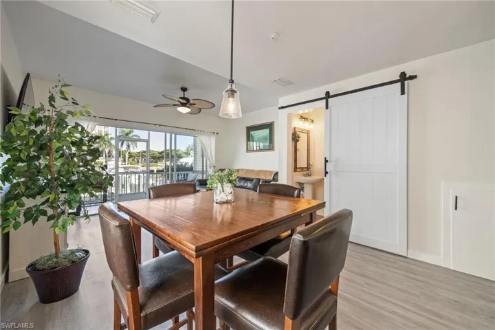 Dining area featuring a wood-finish table, pendant lighting, and wood-finish flooring