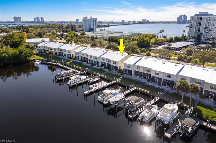Waterfront townhome featuring a private boat dock, direct water access, and multi-story construction