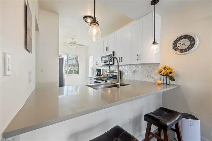 Contemporary kitchen featuring a breakfast bar with stone countertops