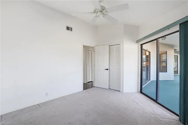Unfurnished bedroom with carpet floors, ceiling fan, a closet, and access to exterior