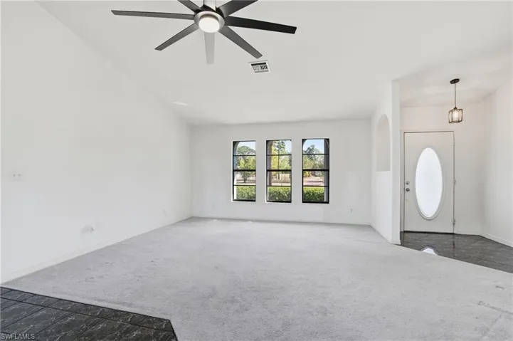 Foyer entrance with carpet floors and ceiling fan