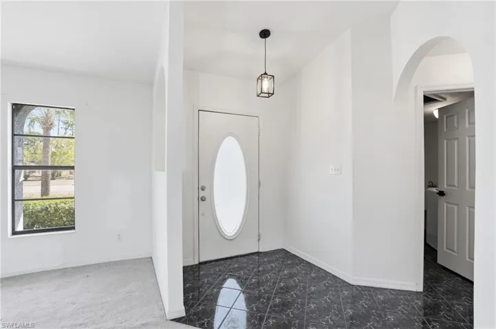 Entryway with baseboards and arched walkways
