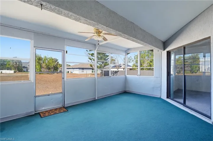 Unfurnished sunroom with a ceiling fan and lofted ceiling
