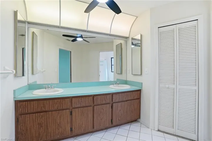 Full bathroom with a closet, double vanity, and light tile patterned floors