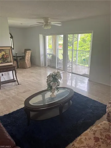 Living area with a textured ceiling and ceiling fan