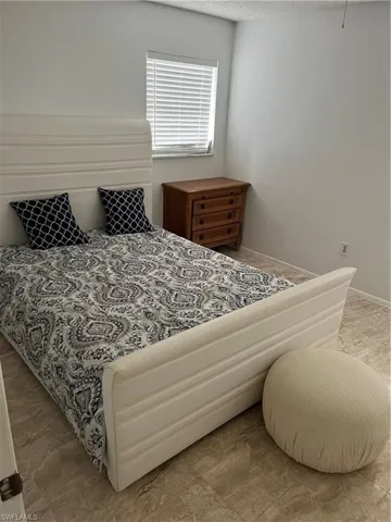 Bedroom featuring a textured ceiling and baseboards