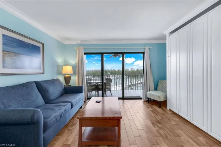 Living room with ornamental molding and light wood-type flooring