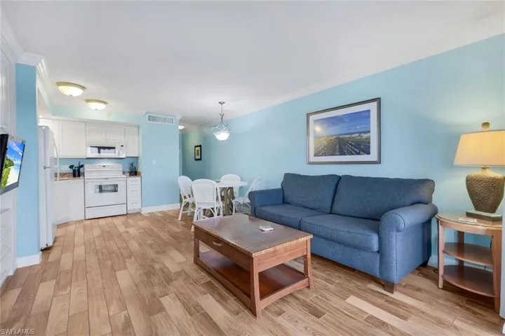 Living room with ornamental molding and light hardwood / wood-style flooring