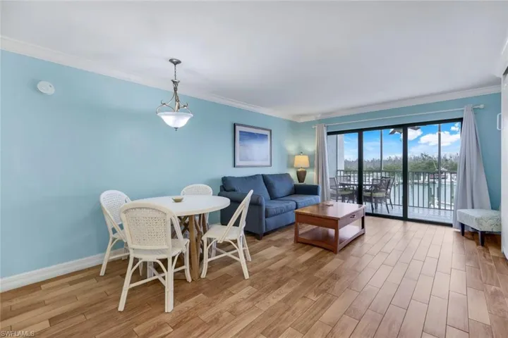 Living room featuring light hardwood / wood-style flooring, ornamental molding, and a water view