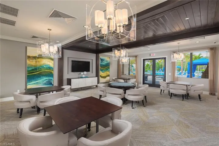 Living room with light colored carpet, crown molding, and french doors
