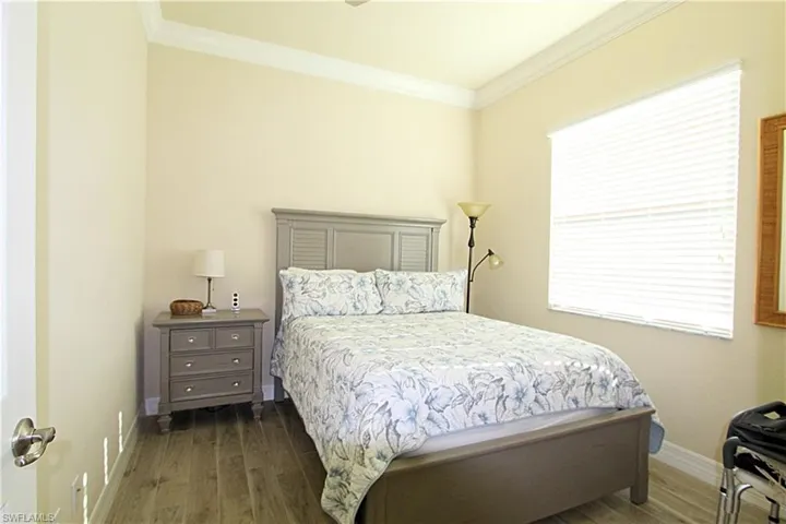Bedroom featuring ornamental molding and dark hardwood / wood-style flooring