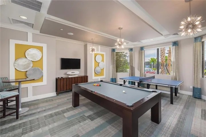 Rec room featuring pool table, a chandelier, and crown molding