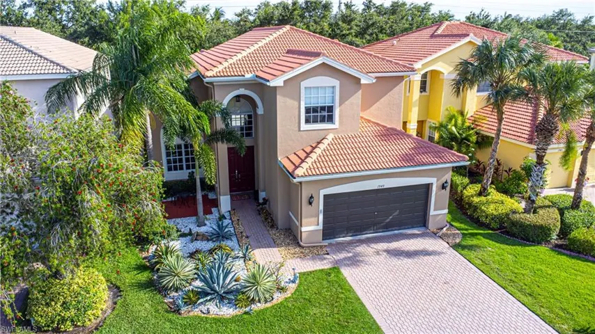 Mediterranean / spanish home featuring a garage and a front lawn