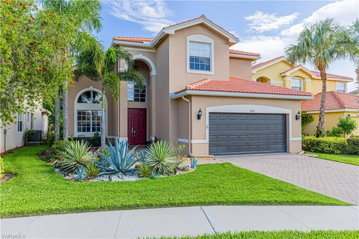 Mediterranean / spanish home featuring a garage and a front yard