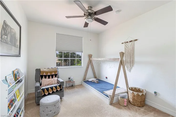 Carpeted bedroom featuring ceiling fan