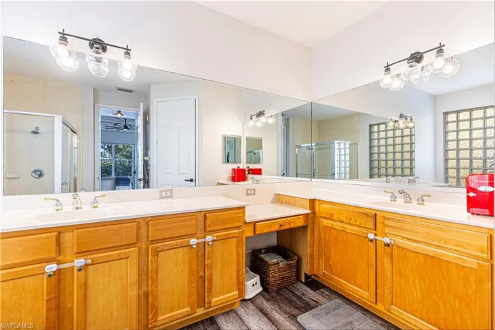 Bathroom featuring walk in shower, wood-type flooring, and vanity