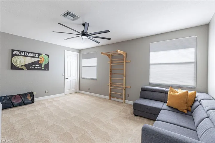 Carpeted living room with ceiling fan