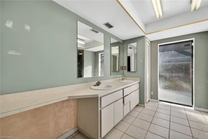 Full bathroom featuring double vanity and light tile patterned floors