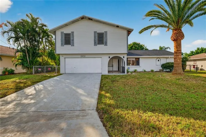 View of front facade with concrete driveway, a garage, and stucco siding