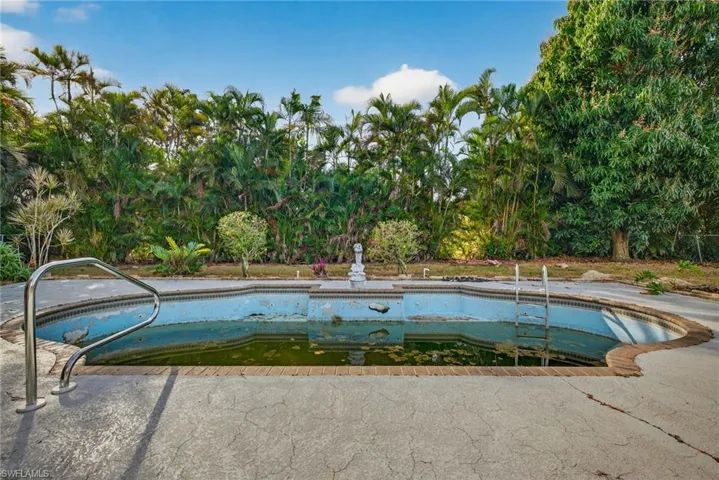 View of swimming pool with a patio area and an empty pool