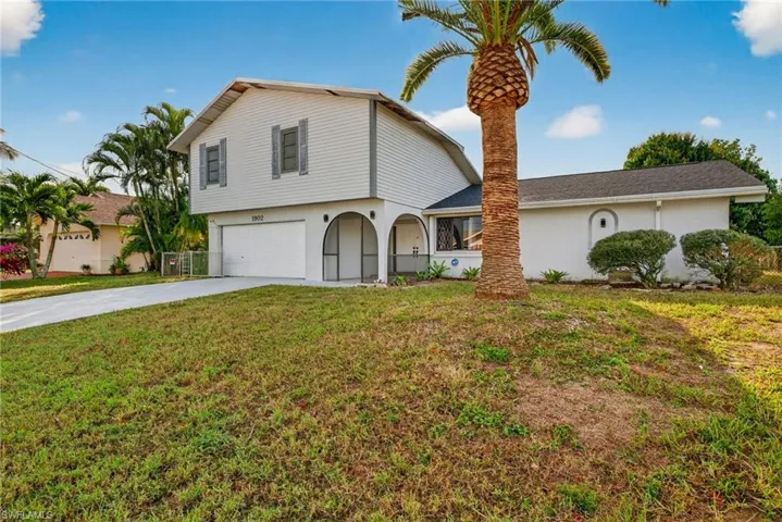 View of front of house featuring driveway, a garage, and stucco siding
