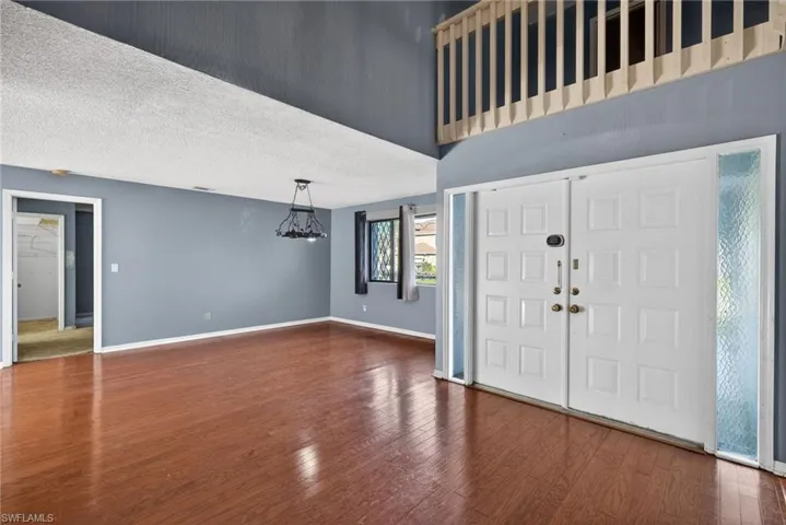 Entryway featuring a textured ceiling, hardwood / wood-style floors, and a chandelier