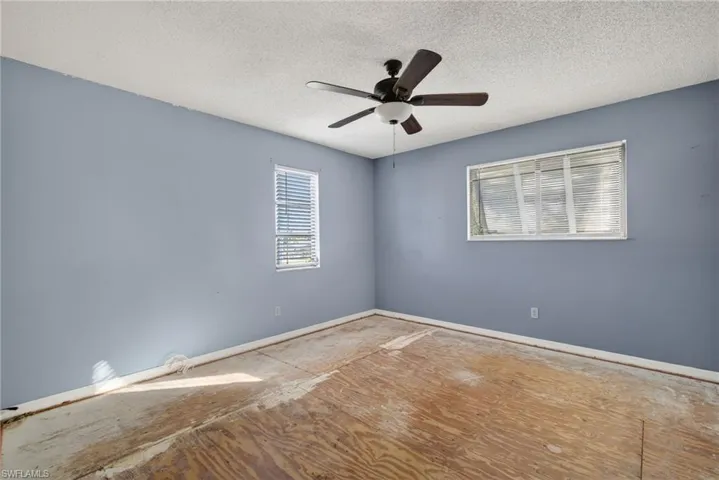 Unfurnished room featuring a textured ceiling and a ceiling fan