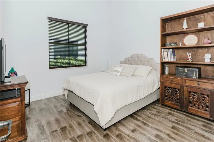 Bedroom with wood finished floors and baseboards