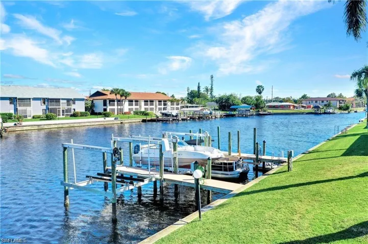 Dock area with a yard and a water view