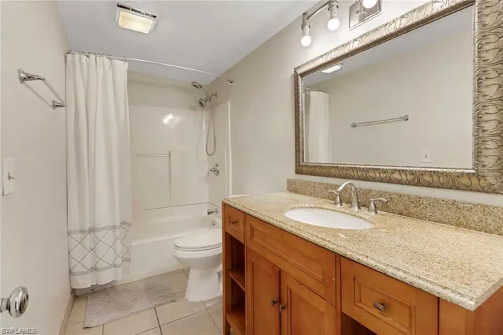 Full bathroom featuring toilet, tile patterned flooring, shower / tub combo, and vanity