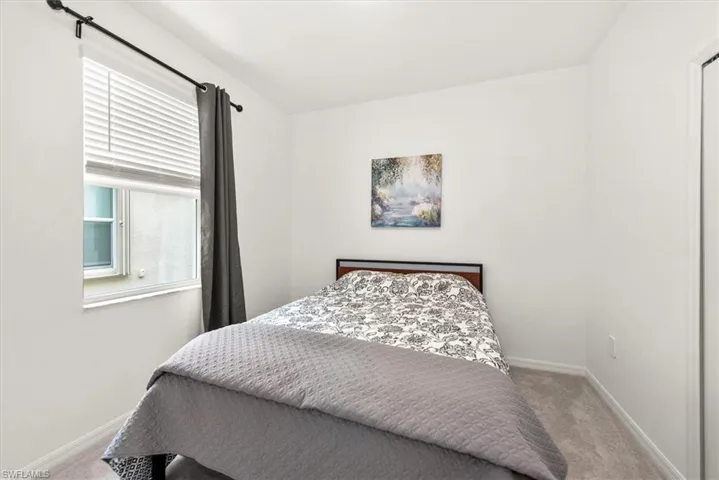 Bright interior space with light gray wall-to-wall carpeting and neutral white walls