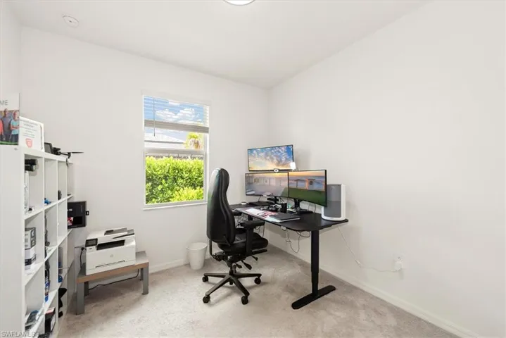 Compact room featuring light-toned walls and plush carpet flooring