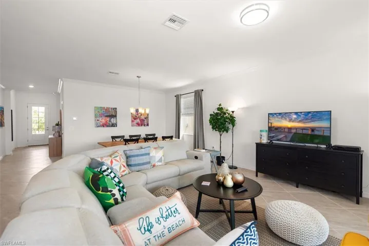 Open-concept living area with neutral tile flooring throughout