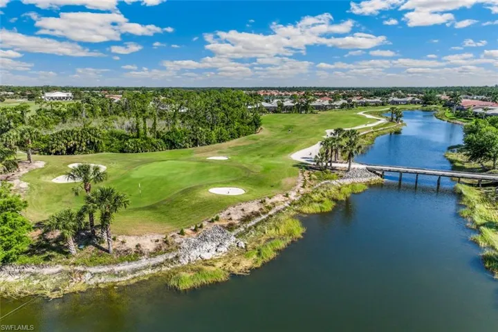 Aerial view showcasing a golf course with green fairways, sand traps, and palm trees