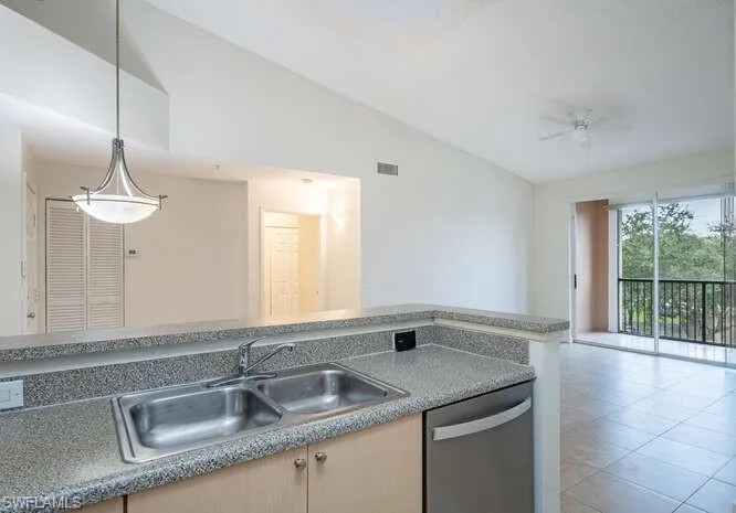 Kitchen with dishwasher, ceiling fan, sink, light tile floors, and lofted ceiling