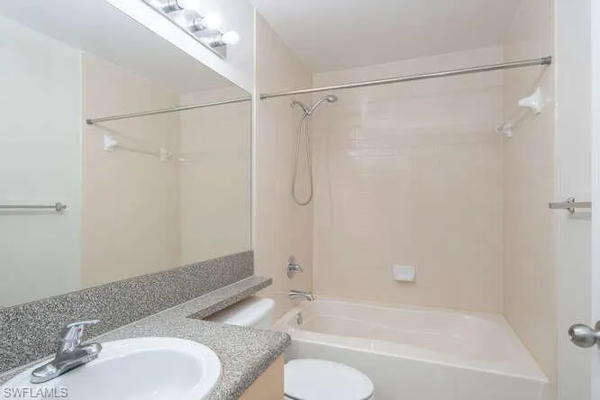 Full bathroom with shower / bath combination, oversized vanity, and toilet