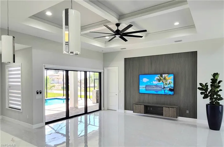 Living room with ceiling fan and beamed ceiling