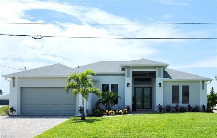 View of front of home with a garage and a front lawn