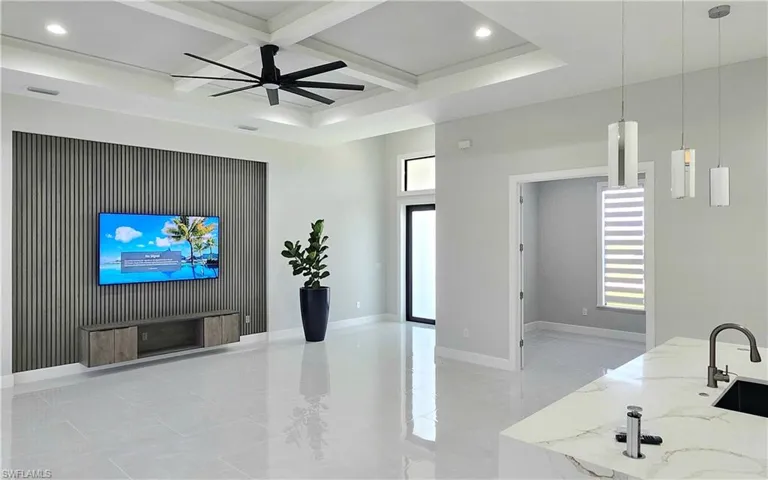 Living room with ceiling fan, beam ceiling, sink, and coffered ceiling