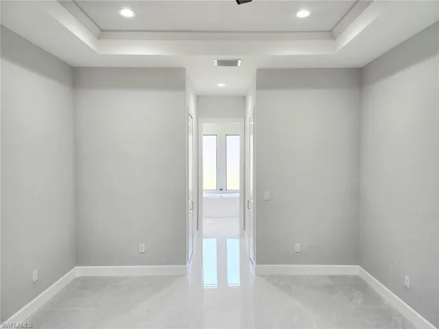 Unfurnished room featuring ornamental molding and a raised ceiling