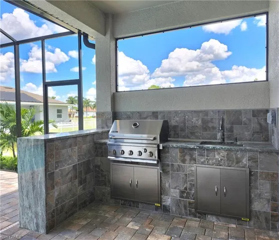 View of patio / terrace featuring area for grilling, sink, and exterior kitchen