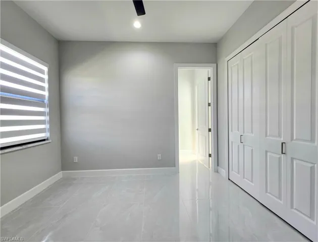 Unfurnished bedroom with ceiling fan and a closet