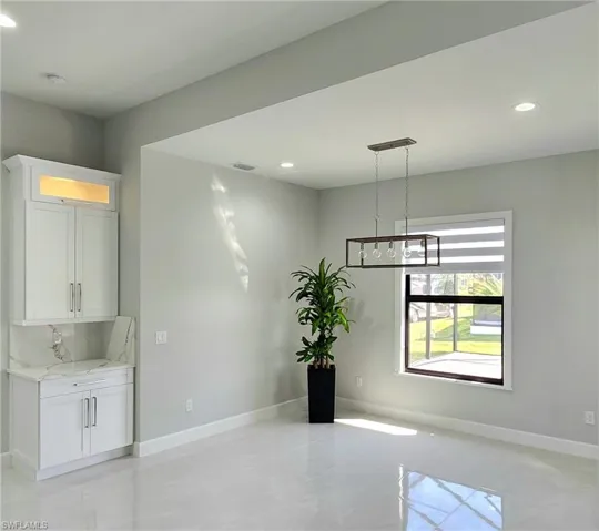 Unfurnished room with a notable chandelier