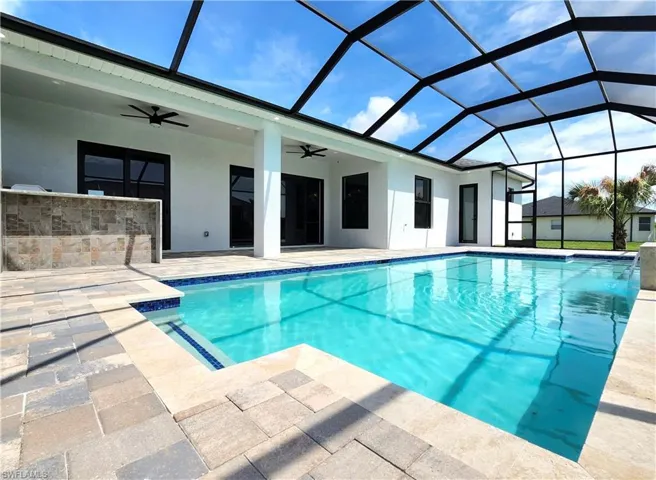View of pool with a lanai, a patio, and ceiling fan