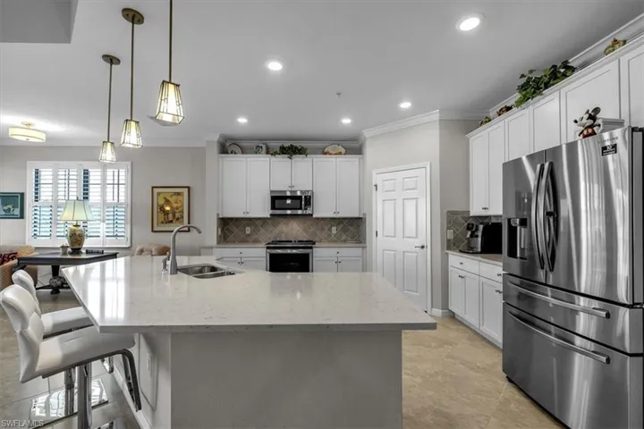 Kitchen with quartz breakfast bar and upgraded lighting and refrigerator