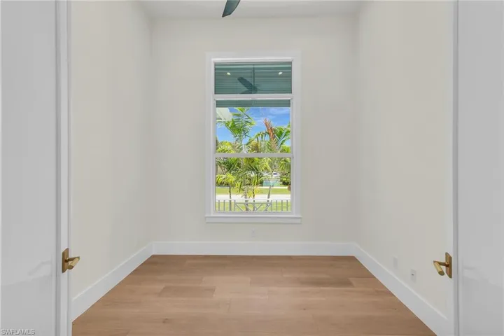 Spare room featuring a wealth of natural light, light wood-style floors, and baseboards