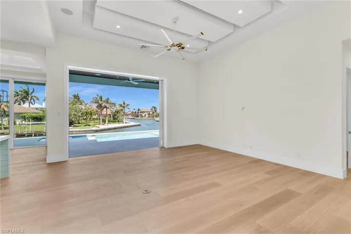 Unfurnished room featuring light wood-style floors, a healthy amount of sunlight, baseboards, and a ceiling fan